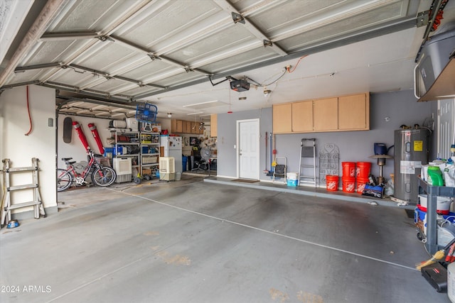 garage with white refrigerator, a garage door opener, and electric water heater