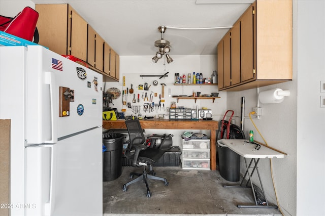 kitchen featuring concrete flooring and white fridge