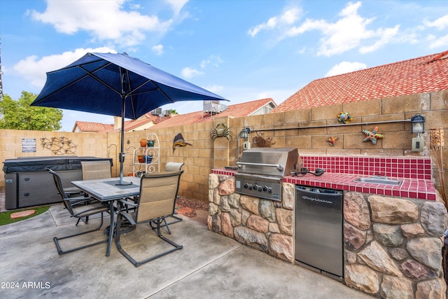 view of patio / terrace featuring a hot tub, an outdoor kitchen, and area for grilling