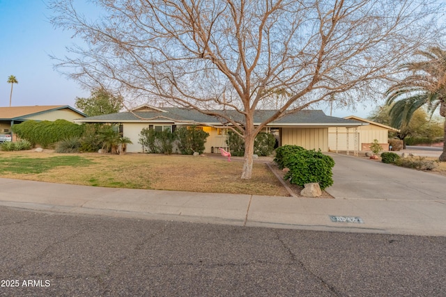 ranch-style house featuring a front lawn and a garage