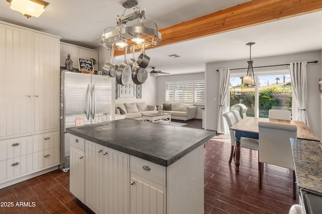 kitchen with ceiling fan, a center island, pendant lighting, stainless steel refrigerator, and white cabinets