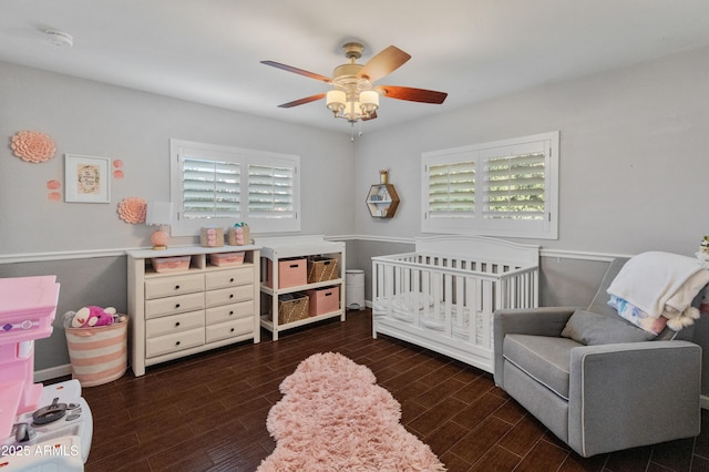 bedroom with ceiling fan and a nursery area