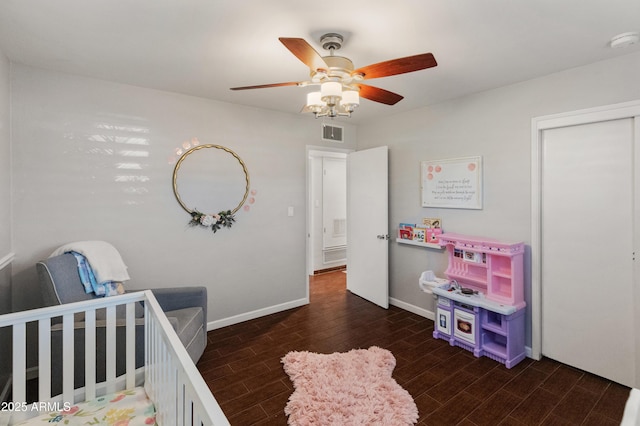 bedroom featuring ceiling fan and a crib