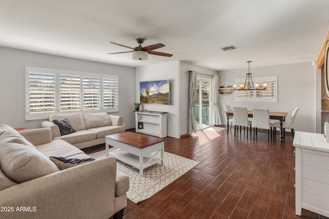 living room with ceiling fan with notable chandelier