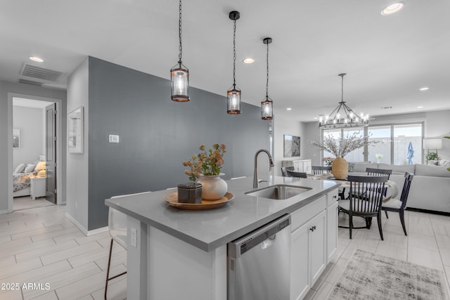 kitchen with stainless steel dishwasher, visible vents, open floor plan, recessed lighting, and a sink