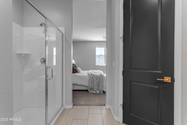 ensuite bathroom featuring baseboards, a shower stall, and ensuite bathroom