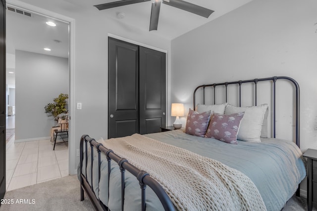 bedroom featuring a ceiling fan, visible vents, tile patterned floors, baseboards, and a closet
