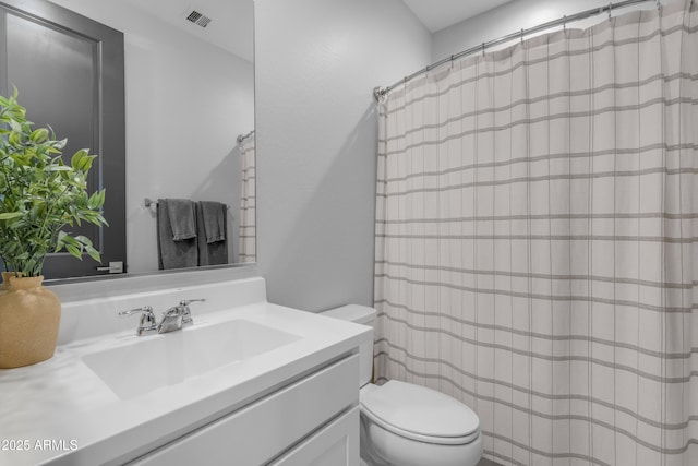full bathroom featuring vanity, toilet, curtained shower, and visible vents