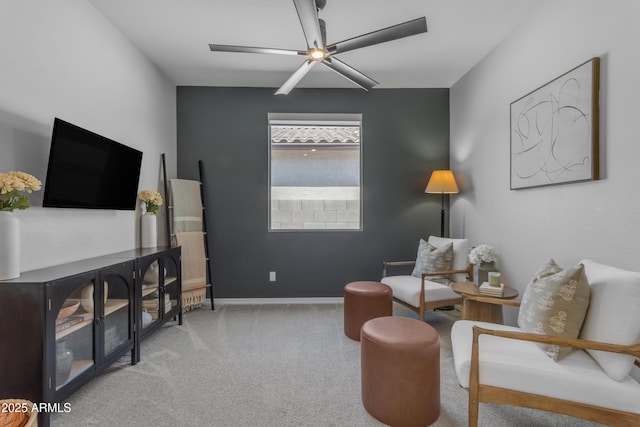 living area with baseboards, carpet, and ceiling fan