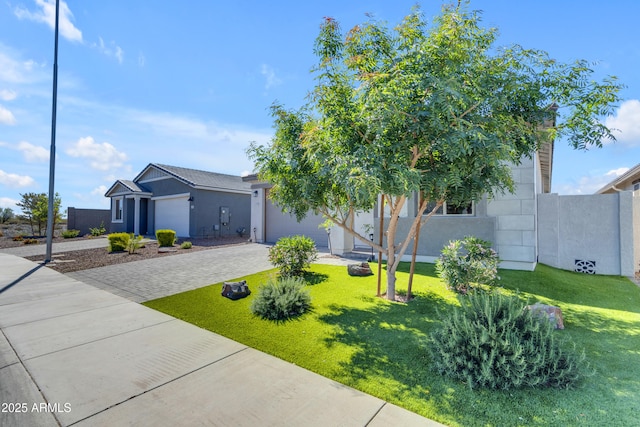 view of front of property with a garage, a front lawn, stucco siding, and driveway