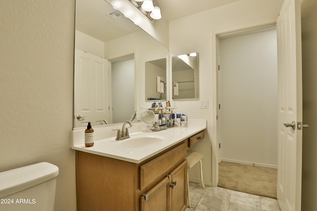 bathroom featuring tile floors, oversized vanity, and toilet