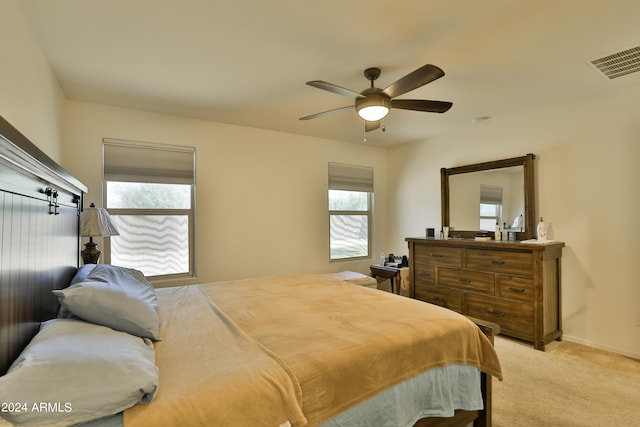 carpeted bedroom featuring multiple windows and ceiling fan