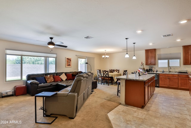 living room featuring ceiling fan with notable chandelier, sink, and light tile floors