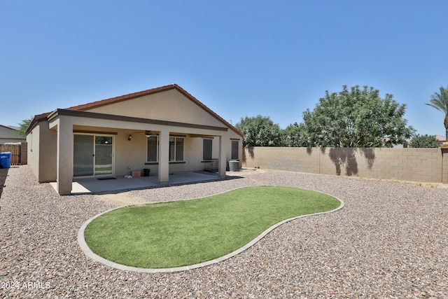 rear view of house with ceiling fan and a patio