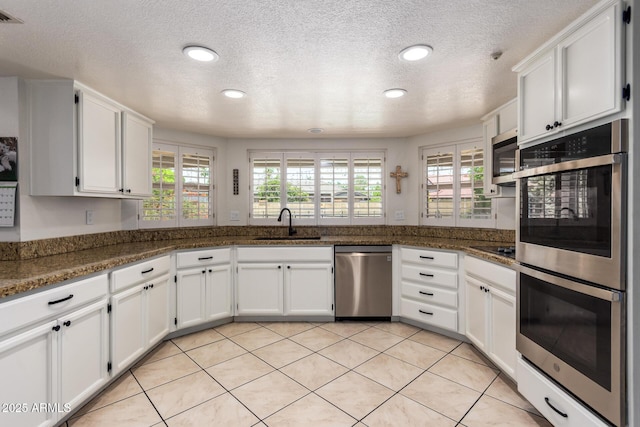 400 W Crofton St, Chandler, AZ 85225 - kitchen with appliances with stainless steel finishes, white cabinetry, a textured ceiling, light tile patterned flooring, and recessed lighting