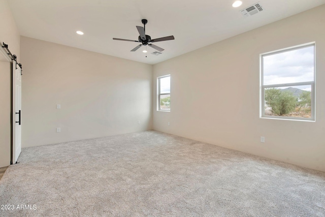 48111 N 7th Ave, New River, AZ 85087 - empty room featuring a barn door, light colored carpet, and a wealth of natural light
