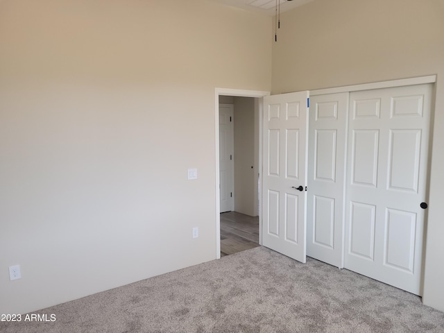48111 N 7th Ave, New River, AZ 85087 - unfurnished bedroom featuring light colored carpet, high vaulted ceiling, and a closet