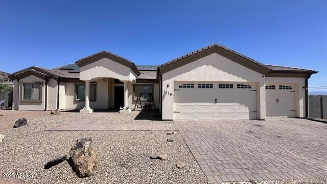 view of front of home featuring a garage and solar panels