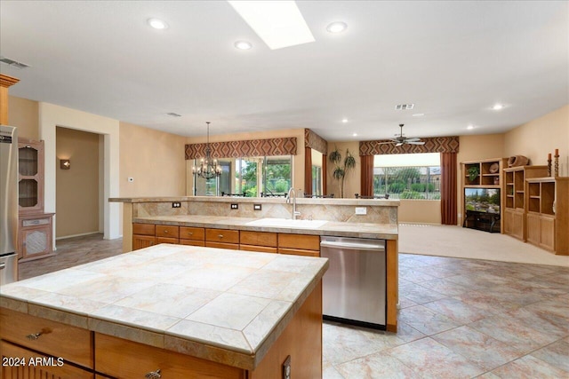 kitchen featuring sink, stainless steel appliances, a healthy amount of sunlight, and a spacious island