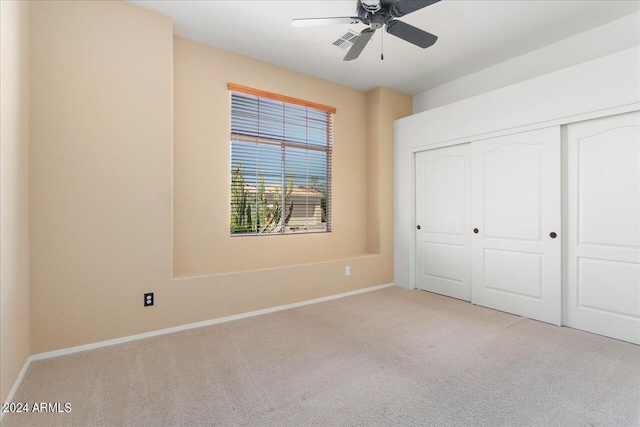 unfurnished bedroom featuring a closet, light carpet, and ceiling fan