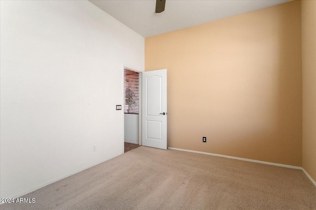 carpeted spare room featuring ceiling fan and high vaulted ceiling