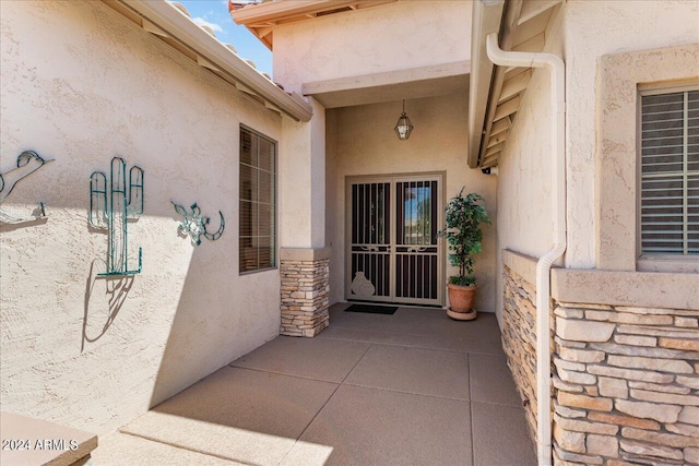 view of exterior entry with a patio area