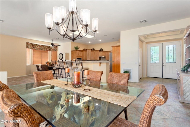 dining room with ceiling fan with notable chandelier and light tile patterned floors