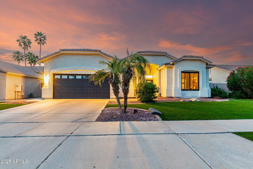 1312 W Bartlett Way, Chandler, AZ 85248 - mediterranean / spanish house featuring concrete driveway, an attached garage, a tiled roof, and stucco siding