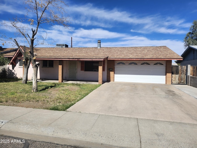 single story home featuring concrete driveway, roof with shingles, an attached garage, and a front yard