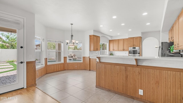 kitchen with oven, a chandelier, healthy amount of natural light, light countertops, and recessed lighting