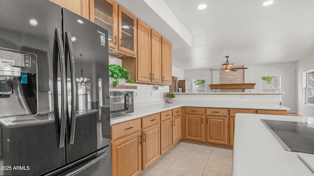 kitchen featuring black appliances, a ceiling fan, light countertops, a peninsula, and glass insert cabinets
