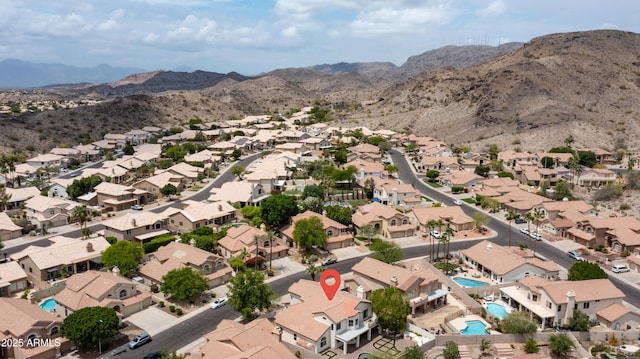 aerial overview of property's location featuring mountains, nearby suburban area, and a pool area