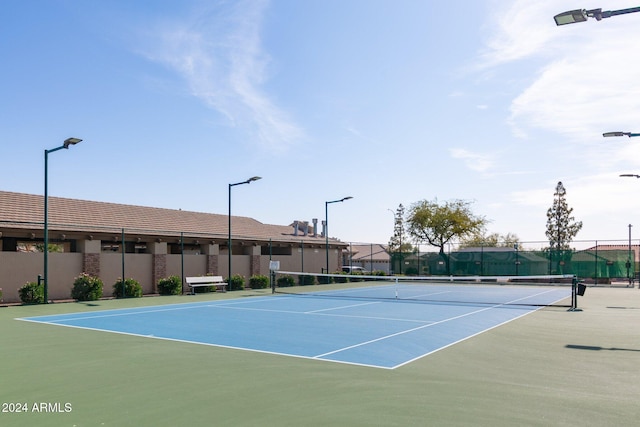 view of tennis court with basketball hoop