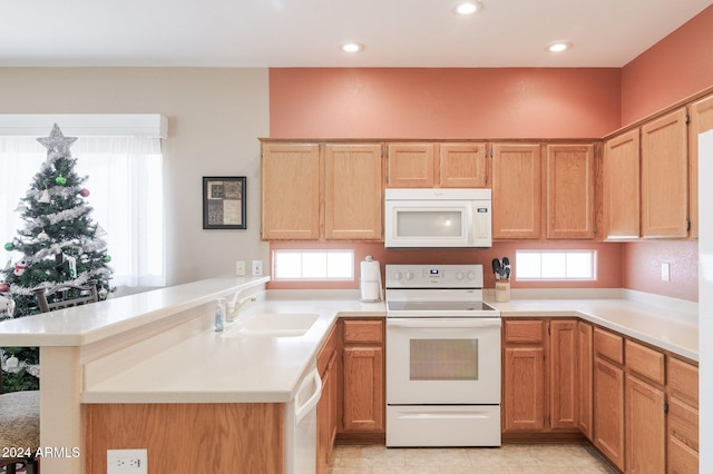 kitchen featuring kitchen peninsula, white appliances, and sink