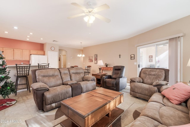 tiled living room with ceiling fan with notable chandelier