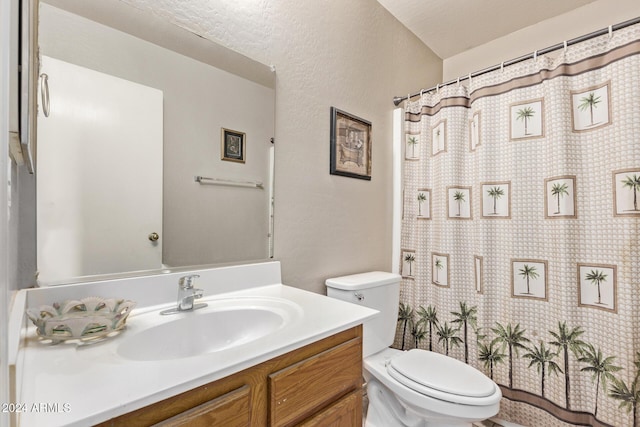 bathroom featuring a textured ceiling, vanity, and toilet