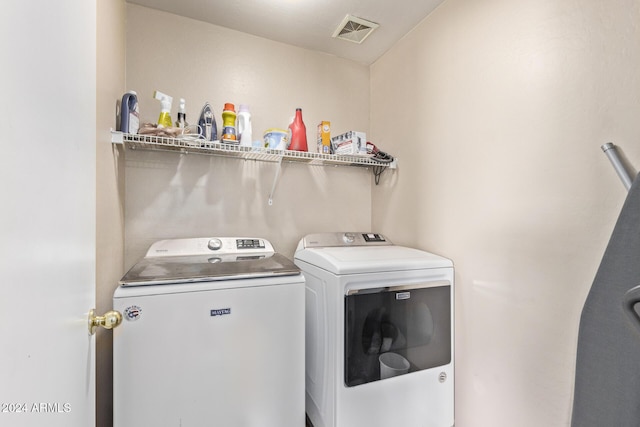 clothes washing area with washing machine and dryer