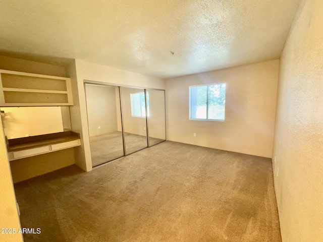 unfurnished bedroom with a closet, carpet flooring, and a textured ceiling