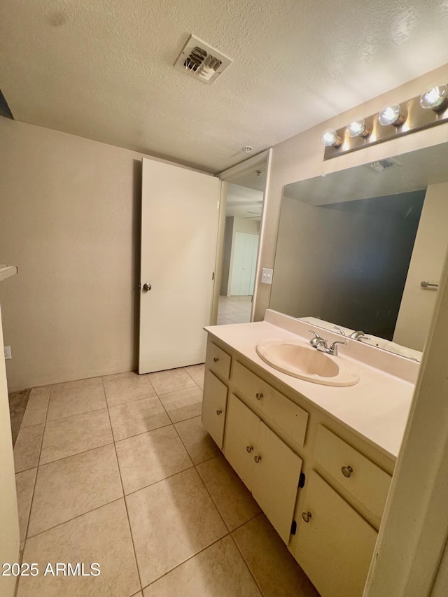 bathroom featuring vanity, tile patterned flooring, and a textured ceiling