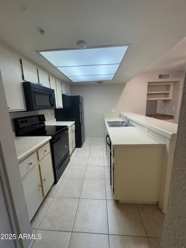 kitchen with light tile patterned floors, sink, and black appliances