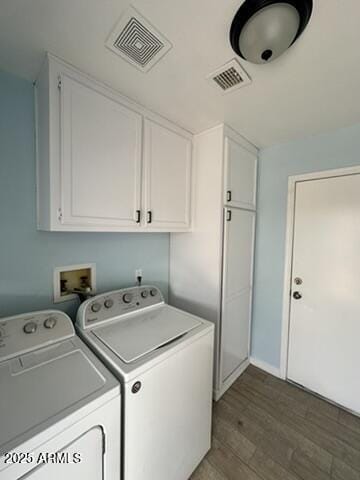 clothes washing area with dark hardwood / wood-style flooring, cabinets, and washing machine and clothes dryer