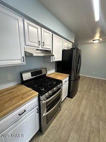 kitchen featuring white cabinetry, butcher block countertops, and range with two ovens