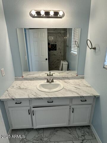 bathroom featuring vanity, toilet, and tiled shower