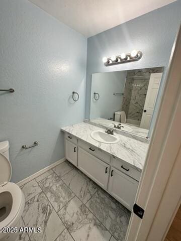 bathroom with vanity, a shower, and toilet