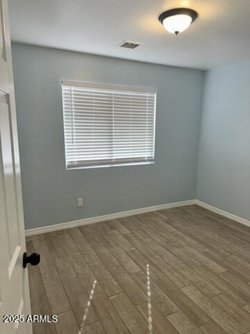 spare room with plenty of natural light and dark hardwood / wood-style floors