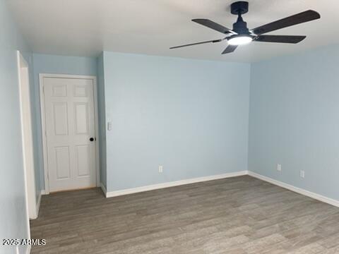 empty room featuring hardwood / wood-style floors and ceiling fan