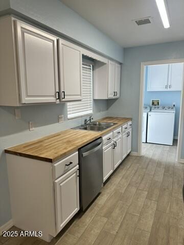 kitchen featuring dishwasher, separate washer and dryer, sink, and white cabinets