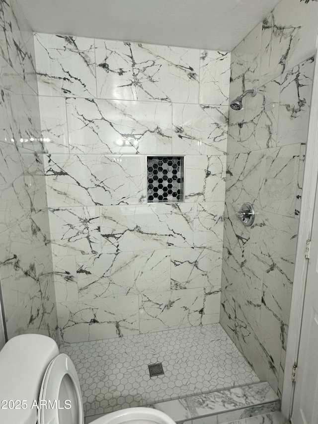 bathroom with tiled shower and toilet