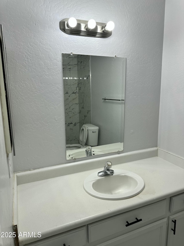 bathroom featuring a shower, vanity, and toilet