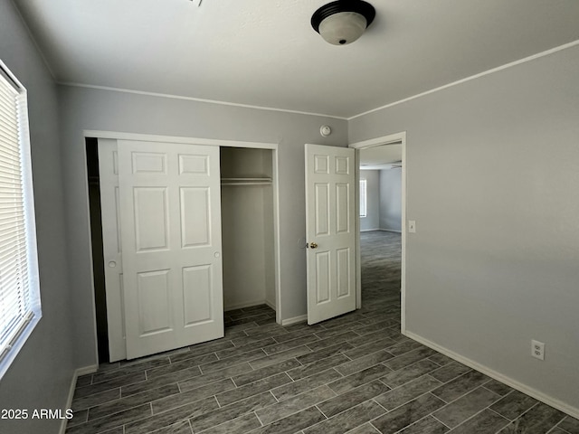 unfurnished bedroom with ornamental molding and a closet